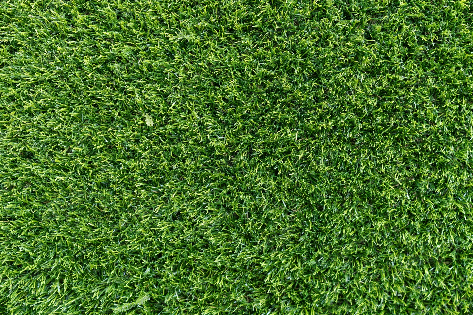 Dense short-cut artificial turf viewed from overhead, filling the frame as a uniform green surface