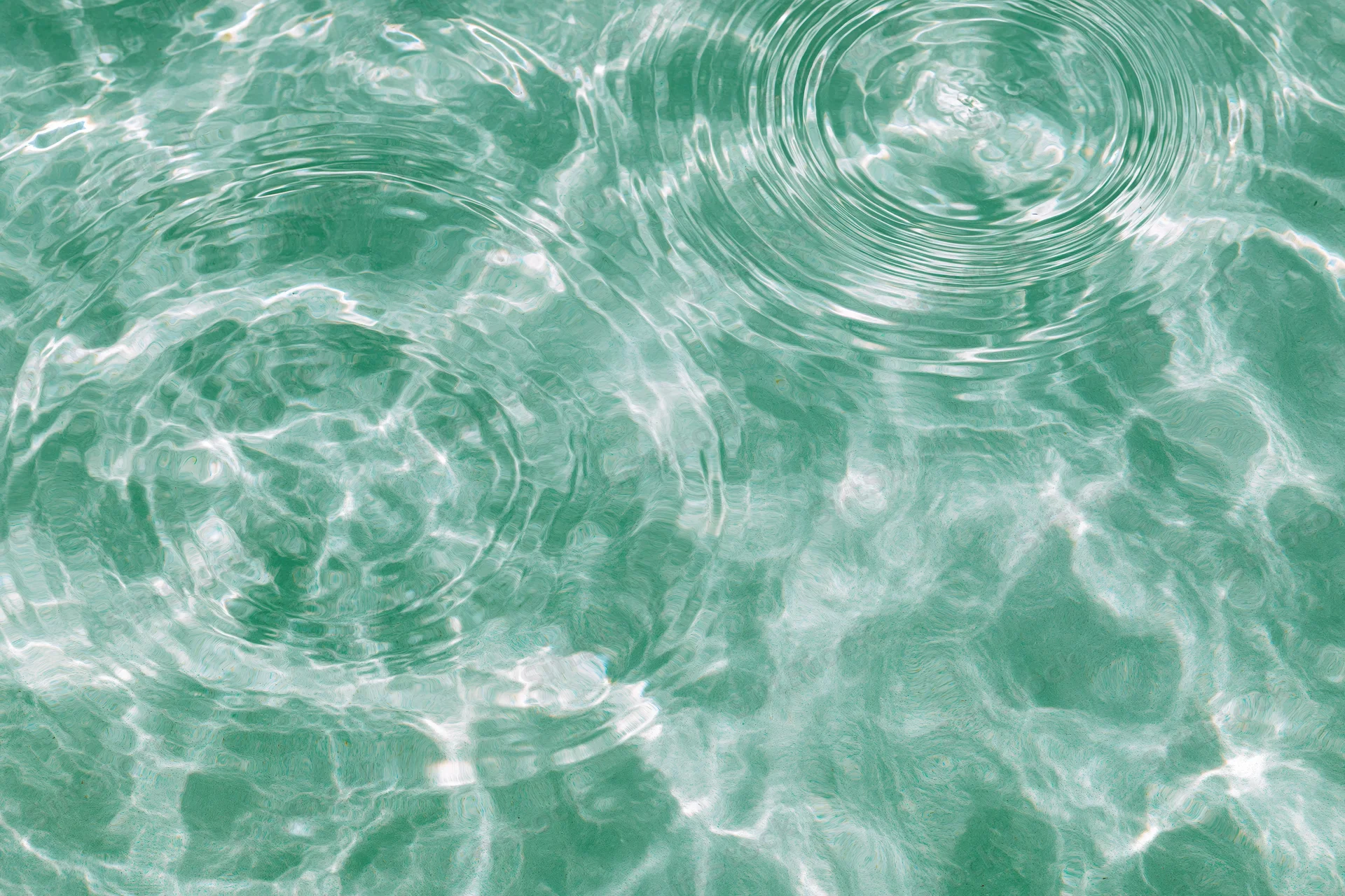 Still water surface with ripples and light reflections from overhead view