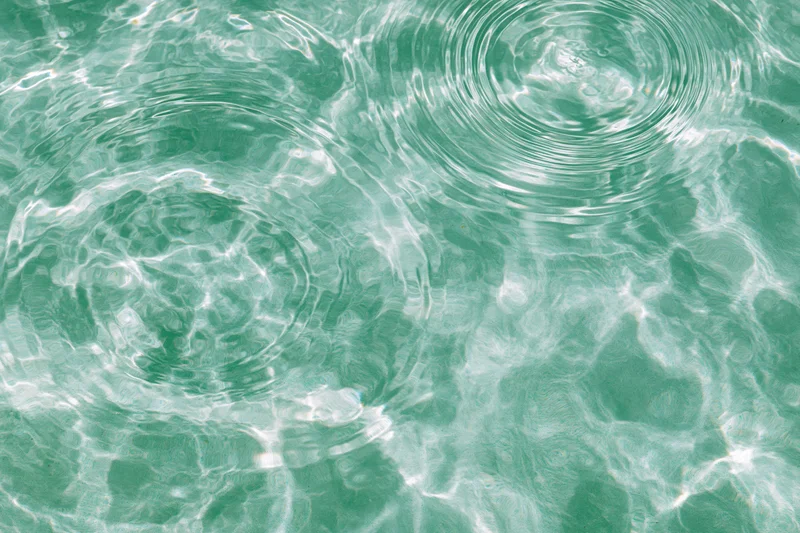 Still water surface with ripples and light reflections from overhead view