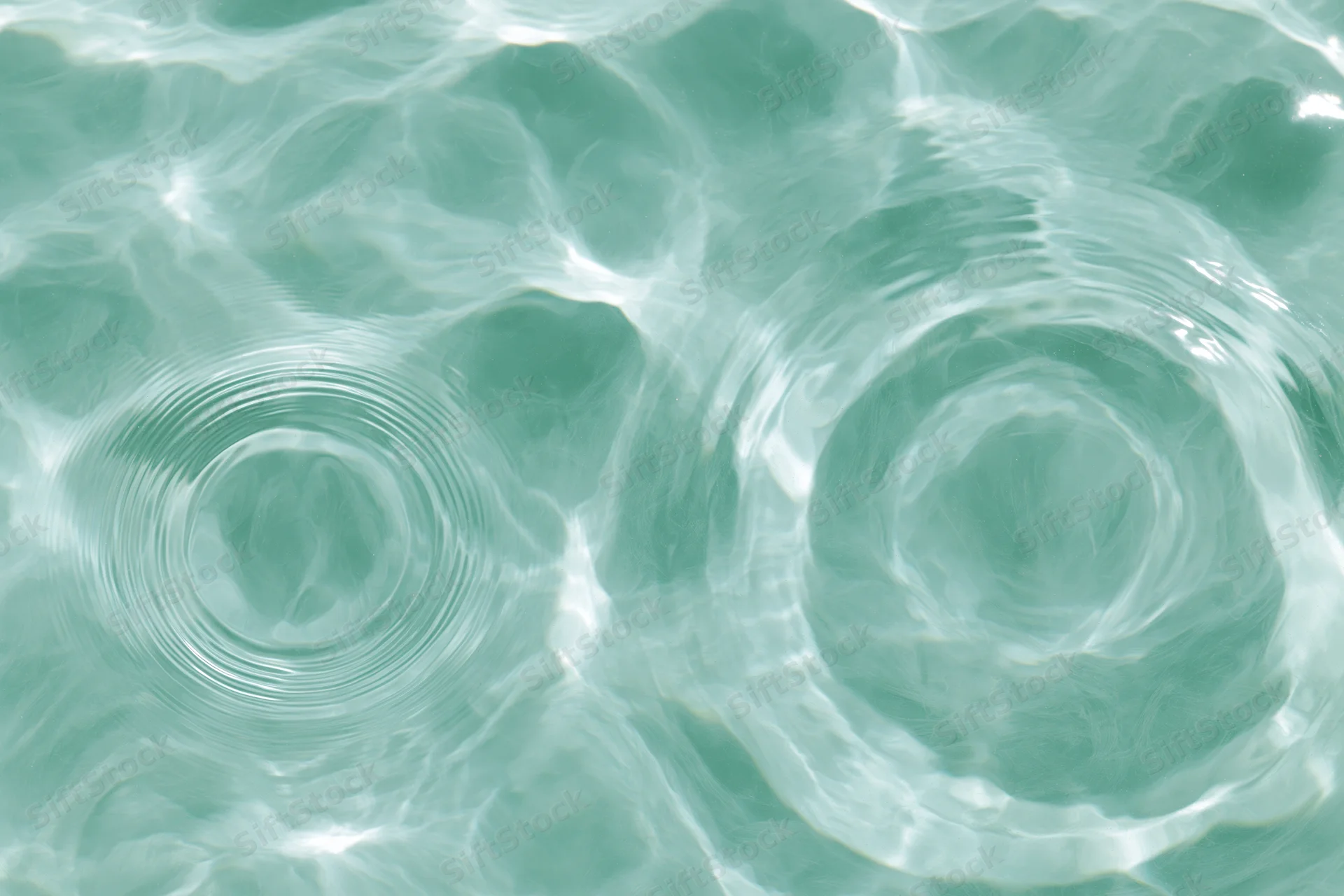 Still water surface with two circular ripples from overhead view