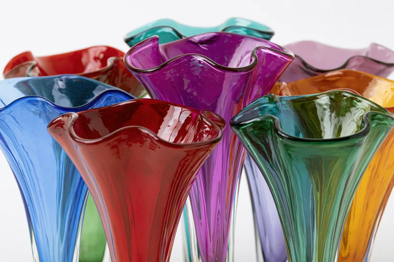 Collection of midcentury murano art glass vases with flared rims arranged closely together on white background