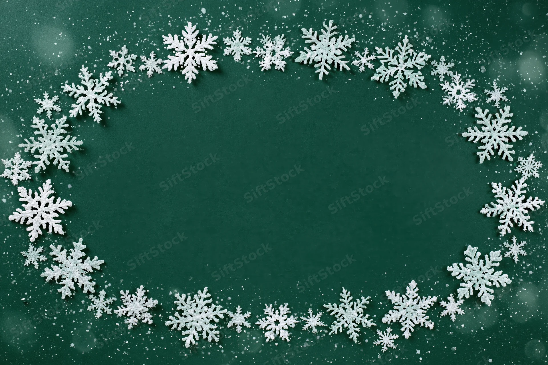 Snowflakes arranged in a circular frame on a green background with copyspace