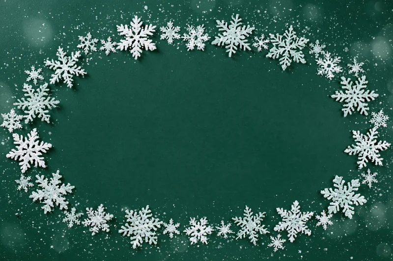 Snowflakes arranged in a circular frame on a green background with copyspace