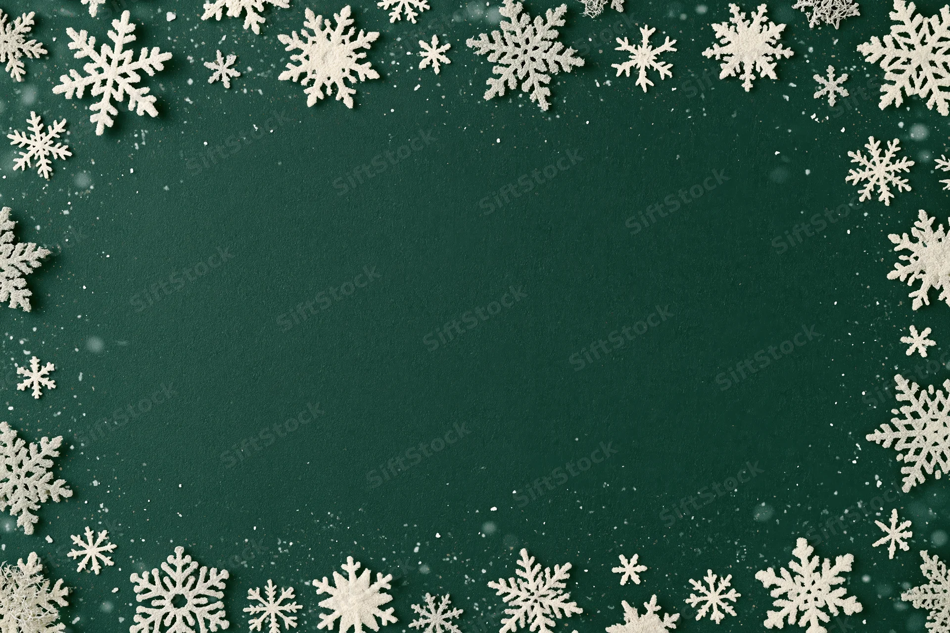 Snowflakes arranged in a border around a green background with copyspace in the center