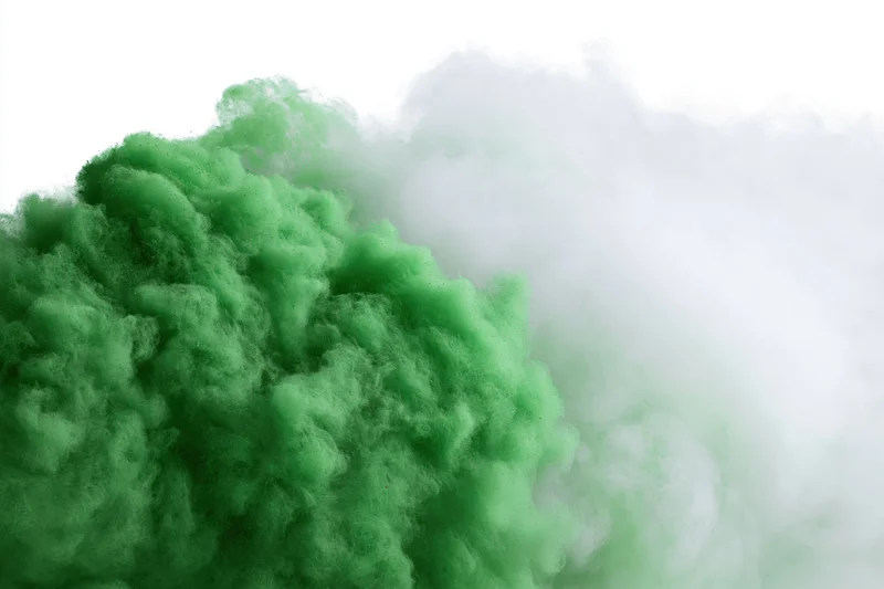 Dense green smoke cloud dissipating against a plain white background