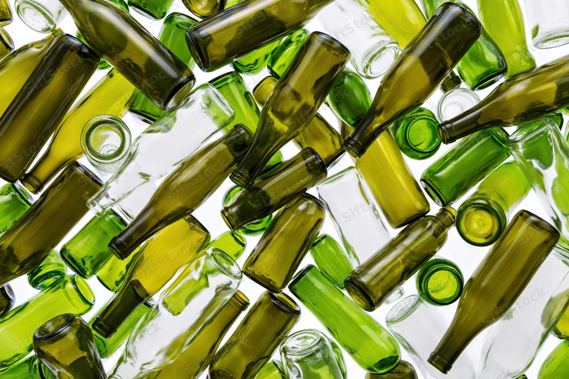 Empty green and clear glass wine bottles scattered on white background