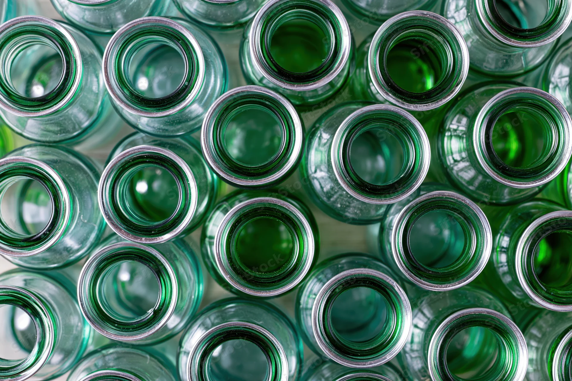 Empty green glass bottles packed tightly together viewed from above