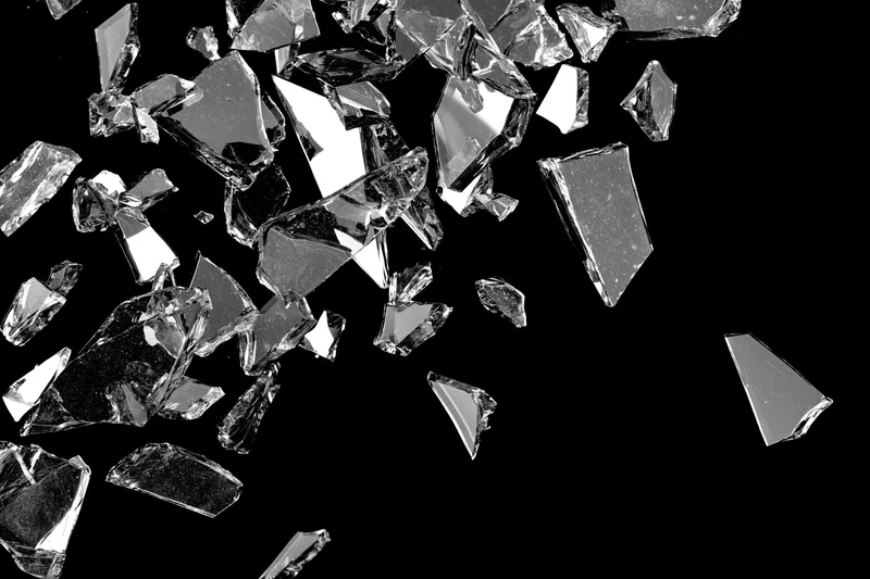 Sharp glass shards suspended midair against black background