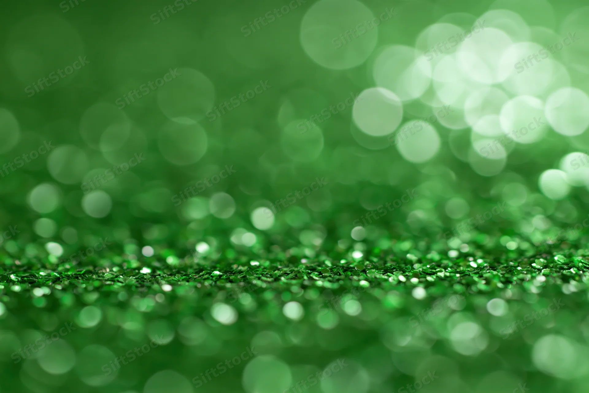 Abstract green glitter surface with bokeh lights and copyspace