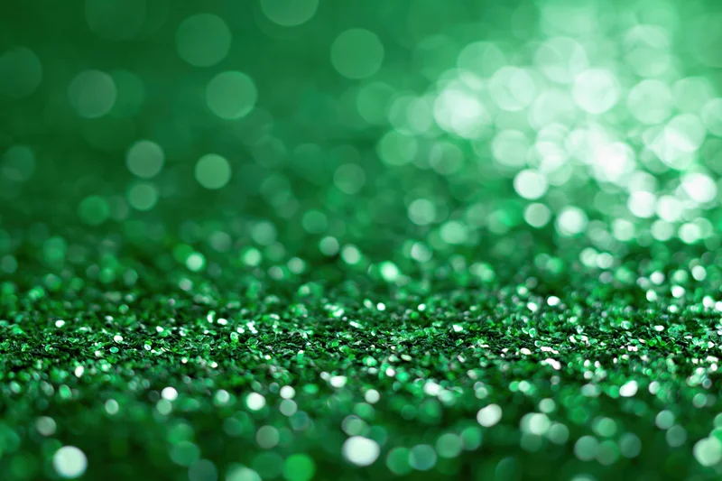 Green glitter surface with bokeh lights and copyspace