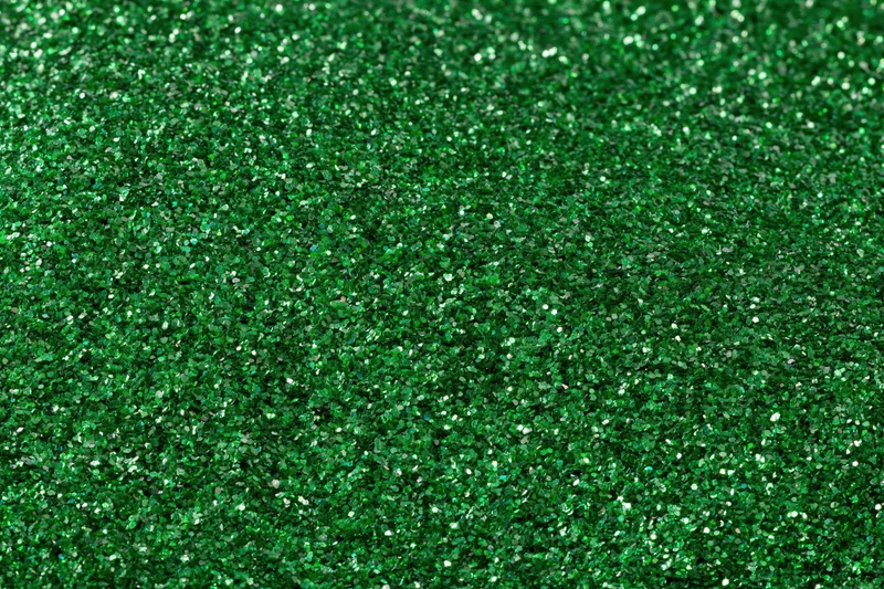 Green glitter surface filling frame in extreme close-up macro view