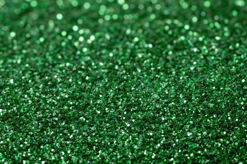 Green glitter surface filling frame in extreme close-up macro view