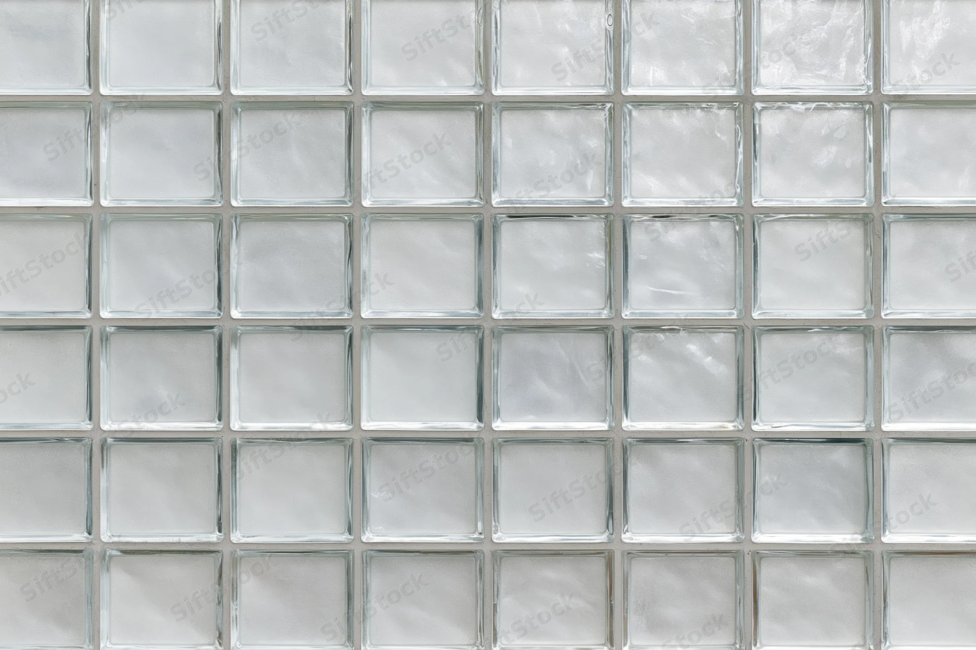 Grid of frosted glass panels arranged in a uniform pattern on a wall