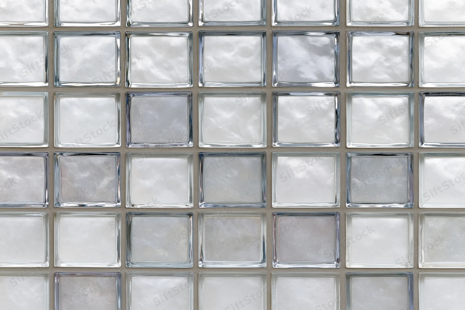 Grid of frosted glass tiles arranged in a square pattern on a wall