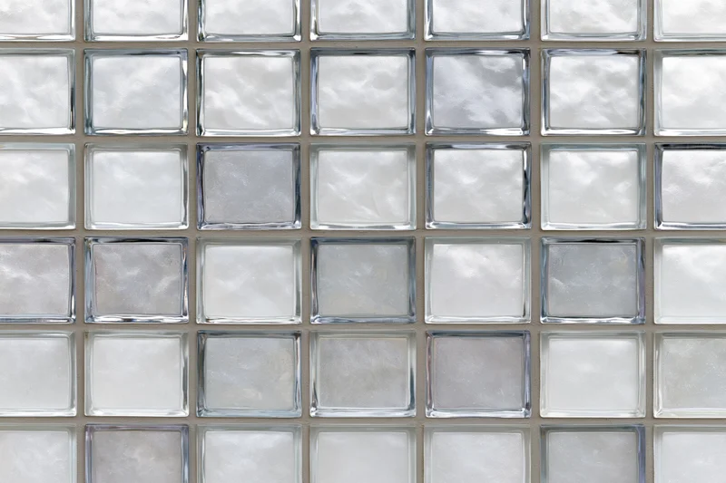 Grid of frosted glass tiles arranged in a square pattern on a wall