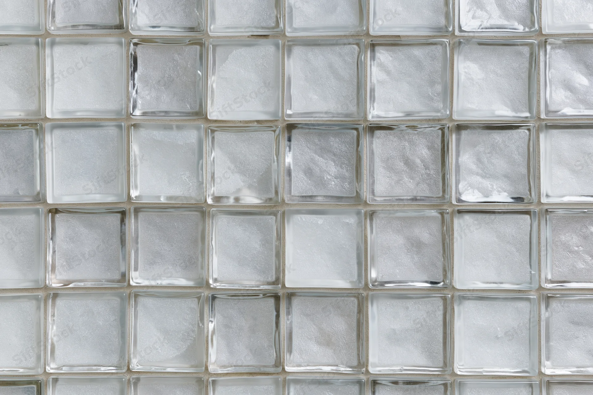 Grid of frosted glass tiles arranged in a square pattern on a wall