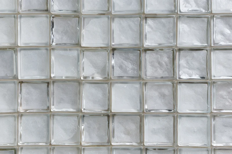 Grid of frosted glass tiles arranged in a square pattern on a wall