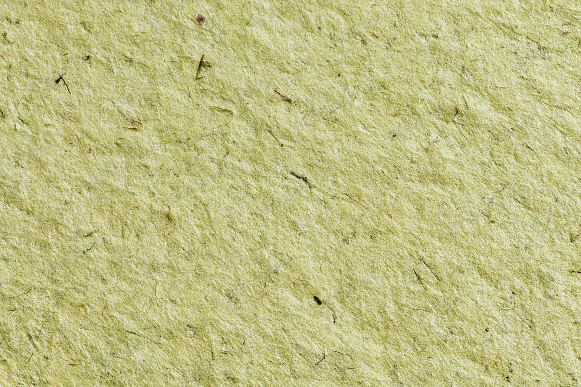 Close-up of a sheet of handmade recycled paper with visible fibers and texture