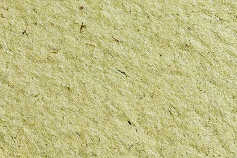 Close-up of a sheet of handmade recycled paper with visible fibers and texture