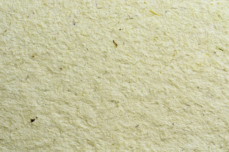 Close-up of handmade recycled paper with visible fibers and natural texture