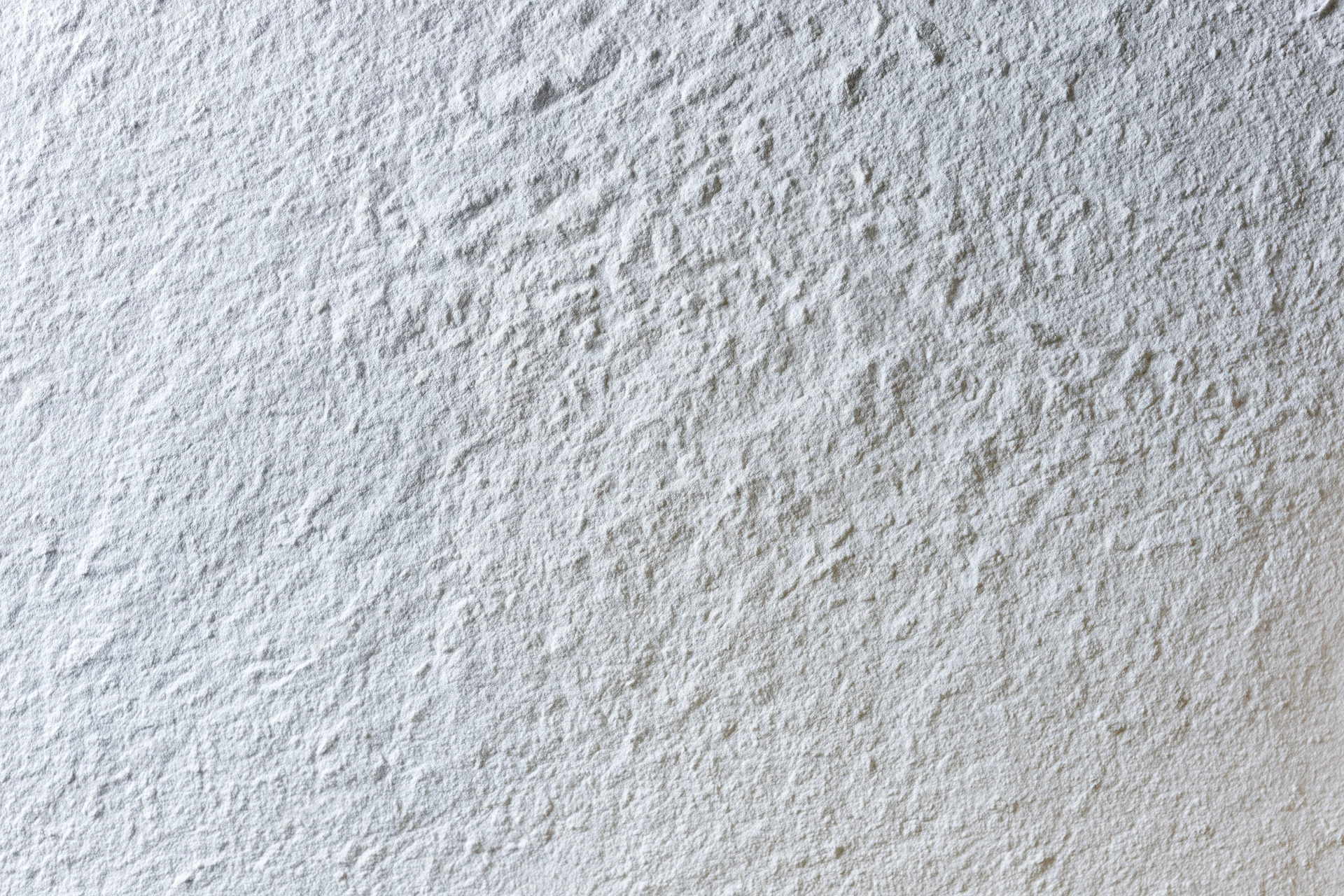Flat matte white wall surface filling the frame with even texture and no visible features