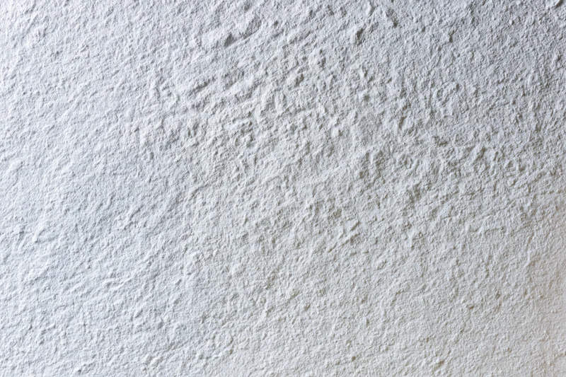 Flat matte white wall surface filling the frame with even texture and no visible features