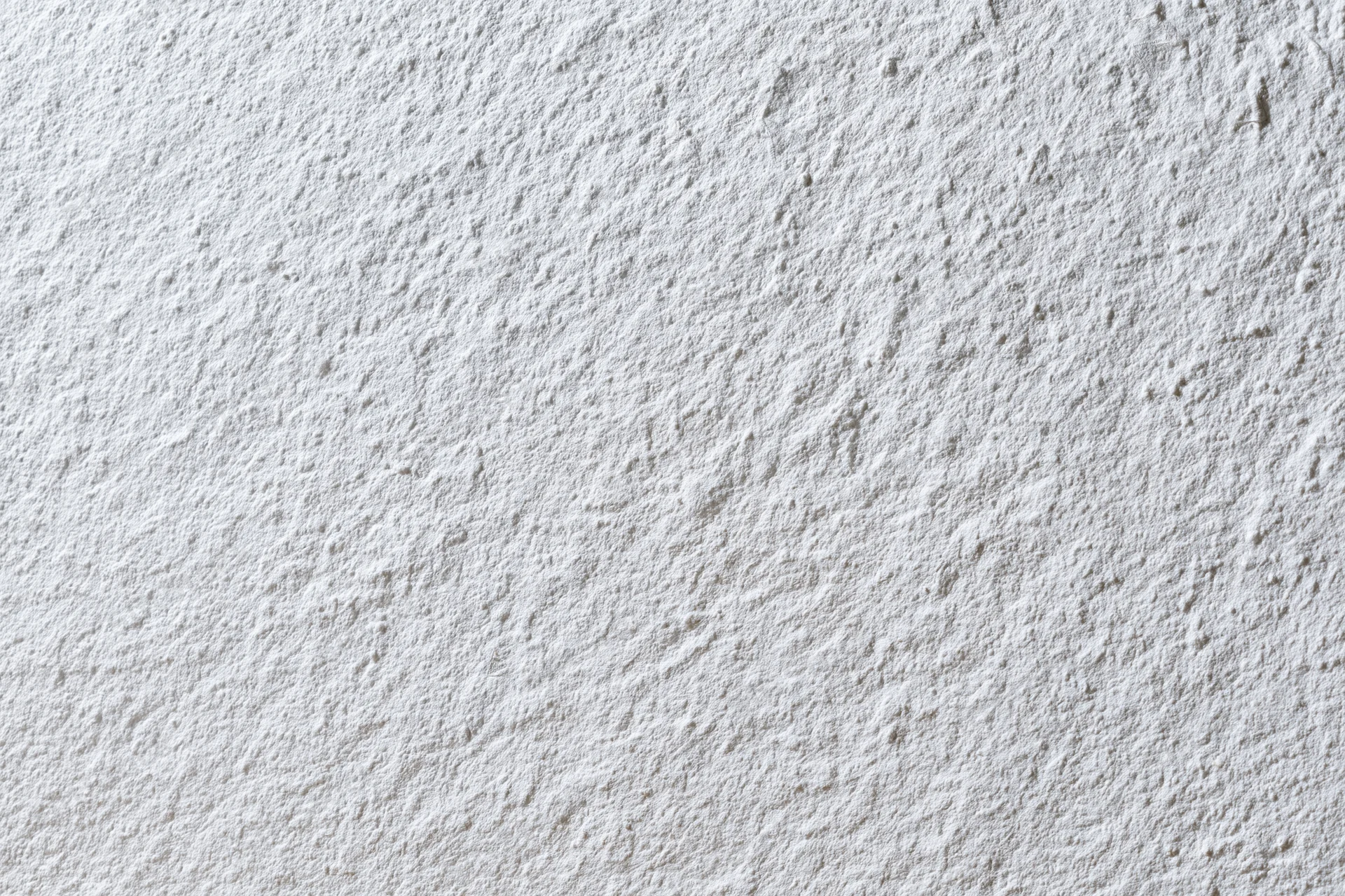 Flat matte white wall surface filling the frame closeup