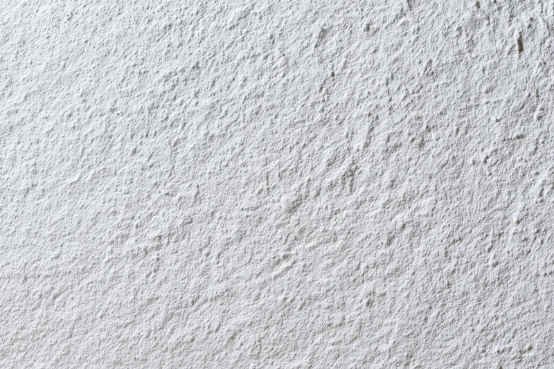 Flat matte white wall surface filling the frame closeup