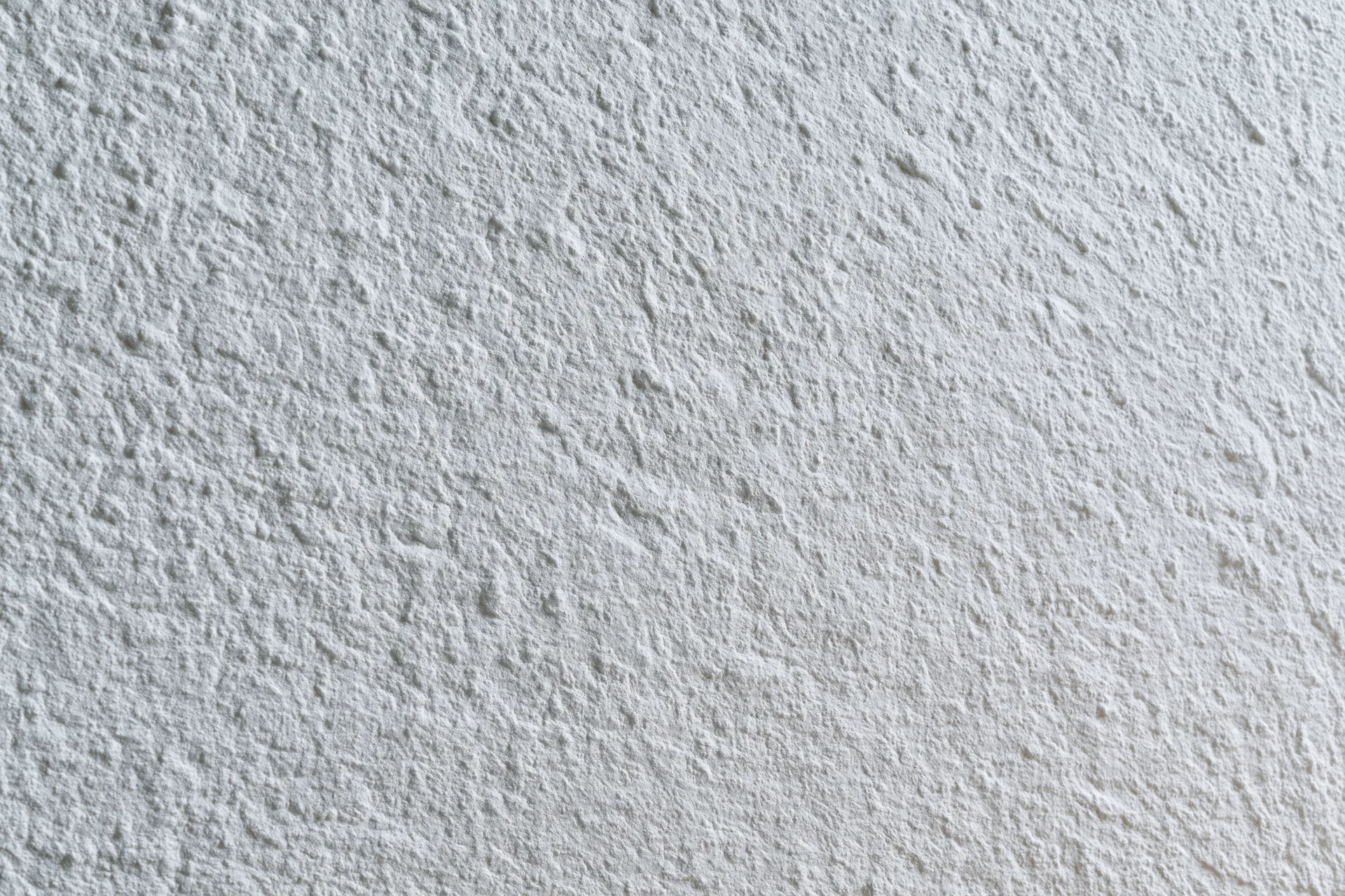 Flat matte white wall surface filling the frame in closeup view