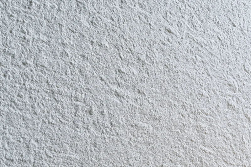 Flat matte white wall surface filling the frame in closeup view
