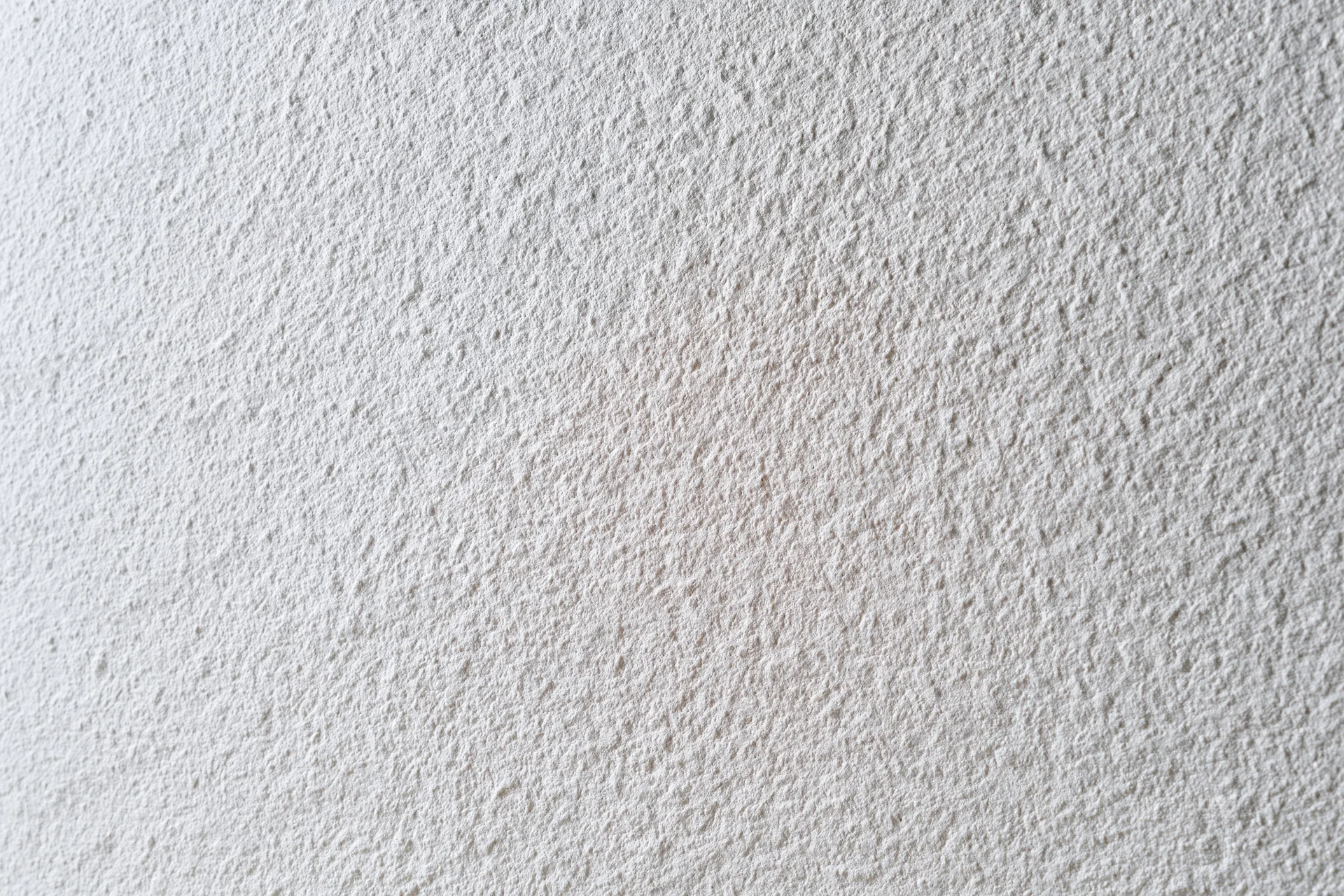 Flat matte white wall surface filling the frame in closeup view