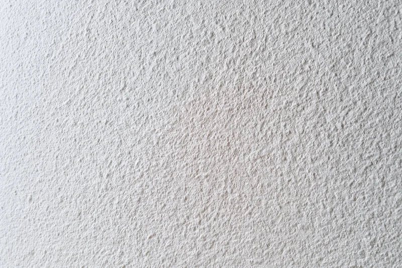 Flat matte white wall surface filling the frame in closeup view