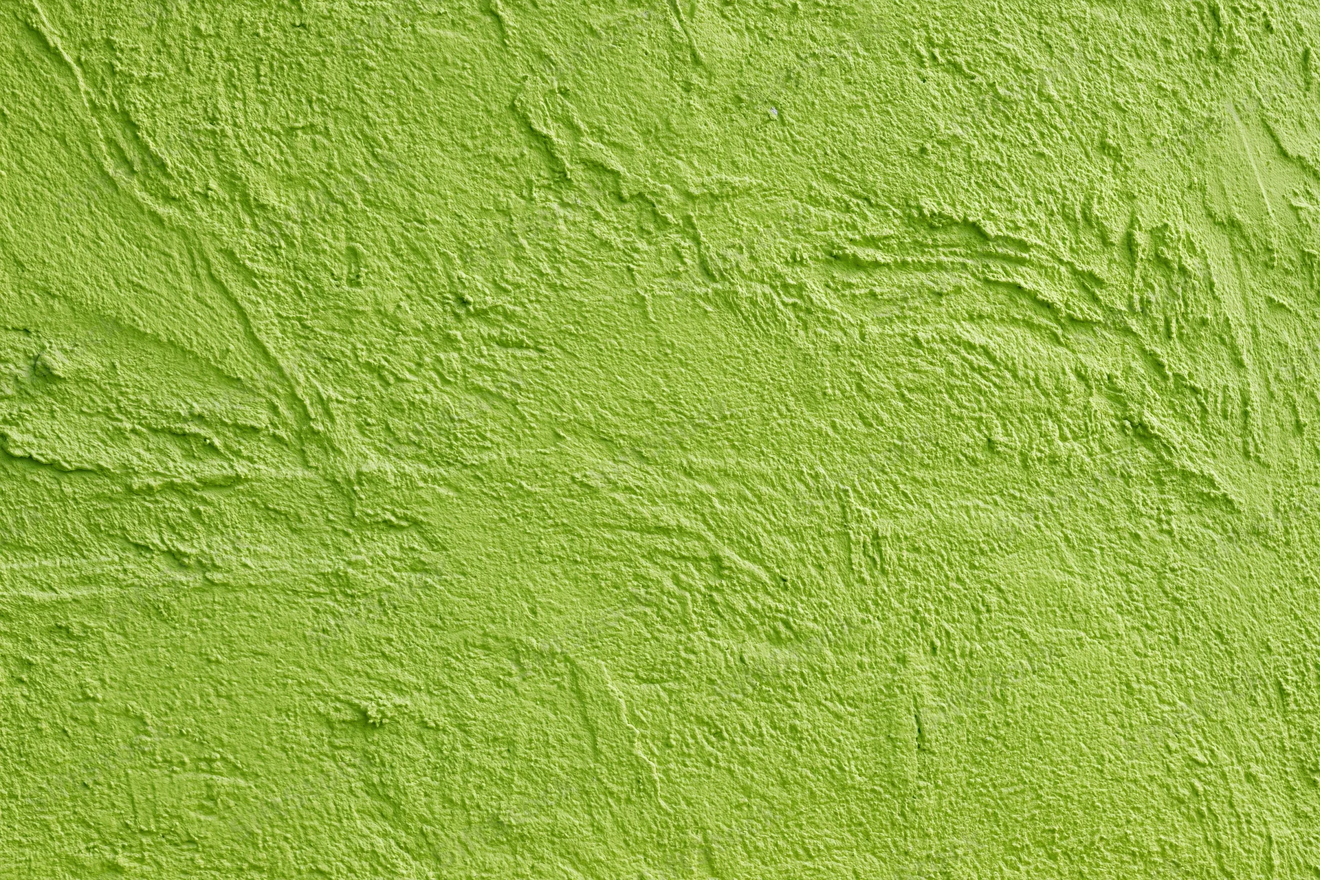 Textured stucco wall painted bright grass green filling the frame