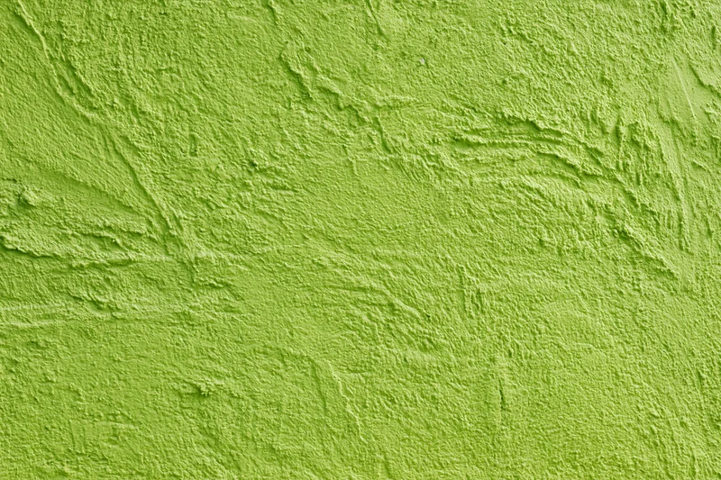 Flat textured stucco wall painted grass green filling the frame