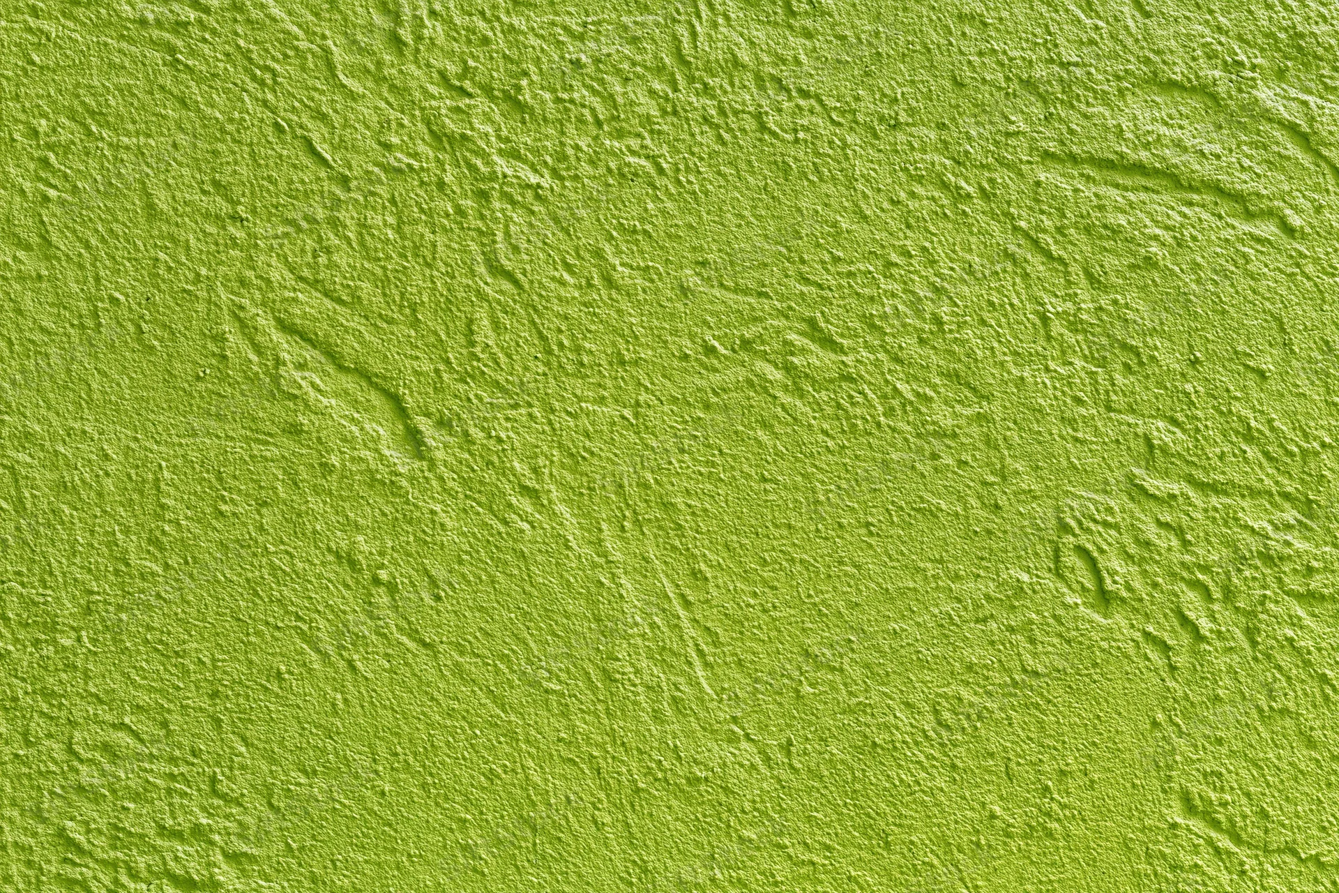 Textured stucco wall painted bright grass green filling the frame