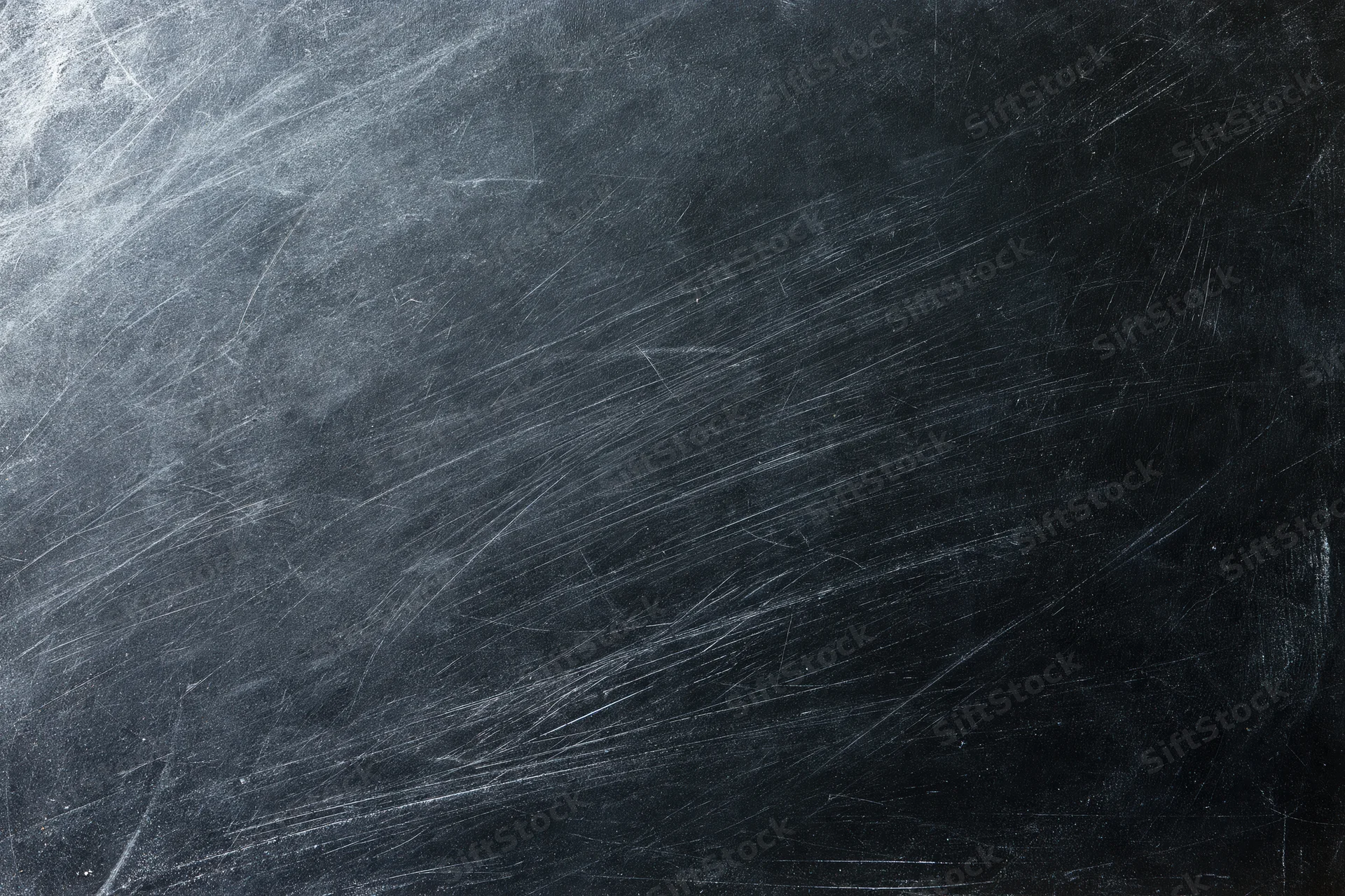 Heavily scratched black surface texture in close-up flat lay arrangement