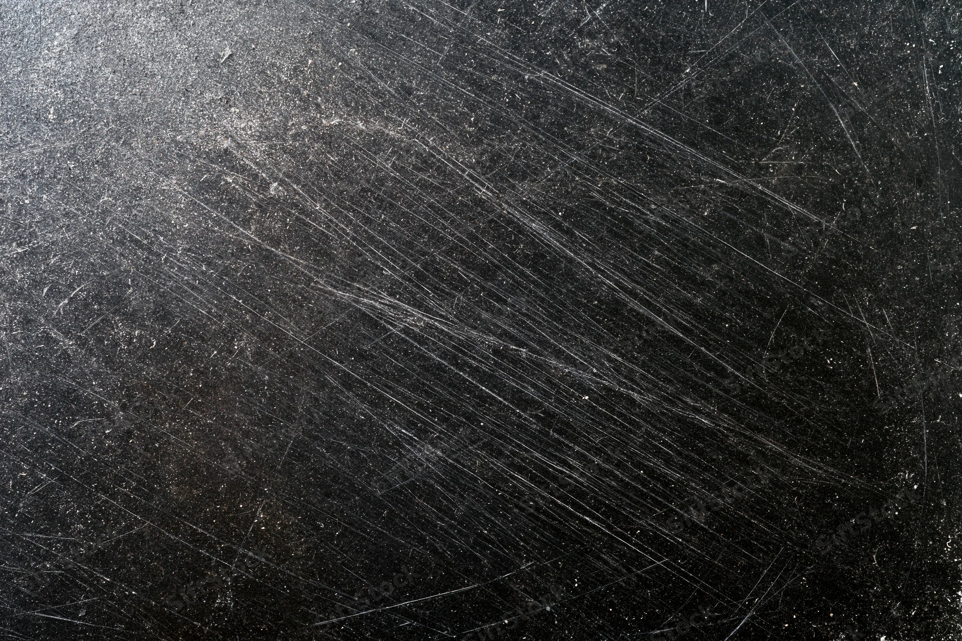 Heavily scratched black surface in close-up flat lay view