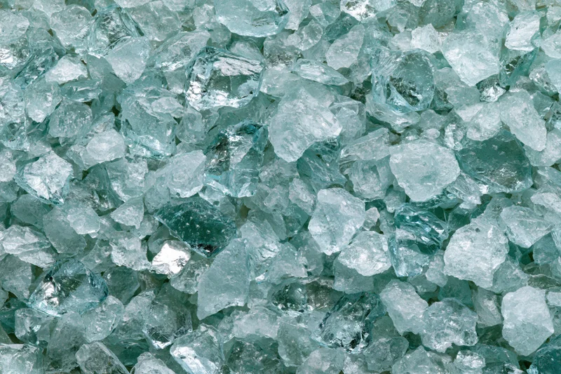 Crushed tempered glass fragments densely packed in a pile