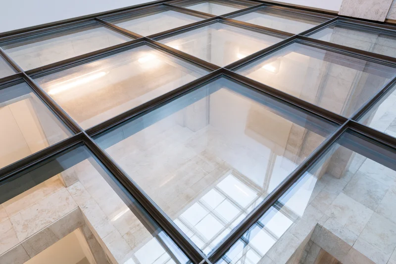 Transparent glass floor panel viewed from above in a modern building interior