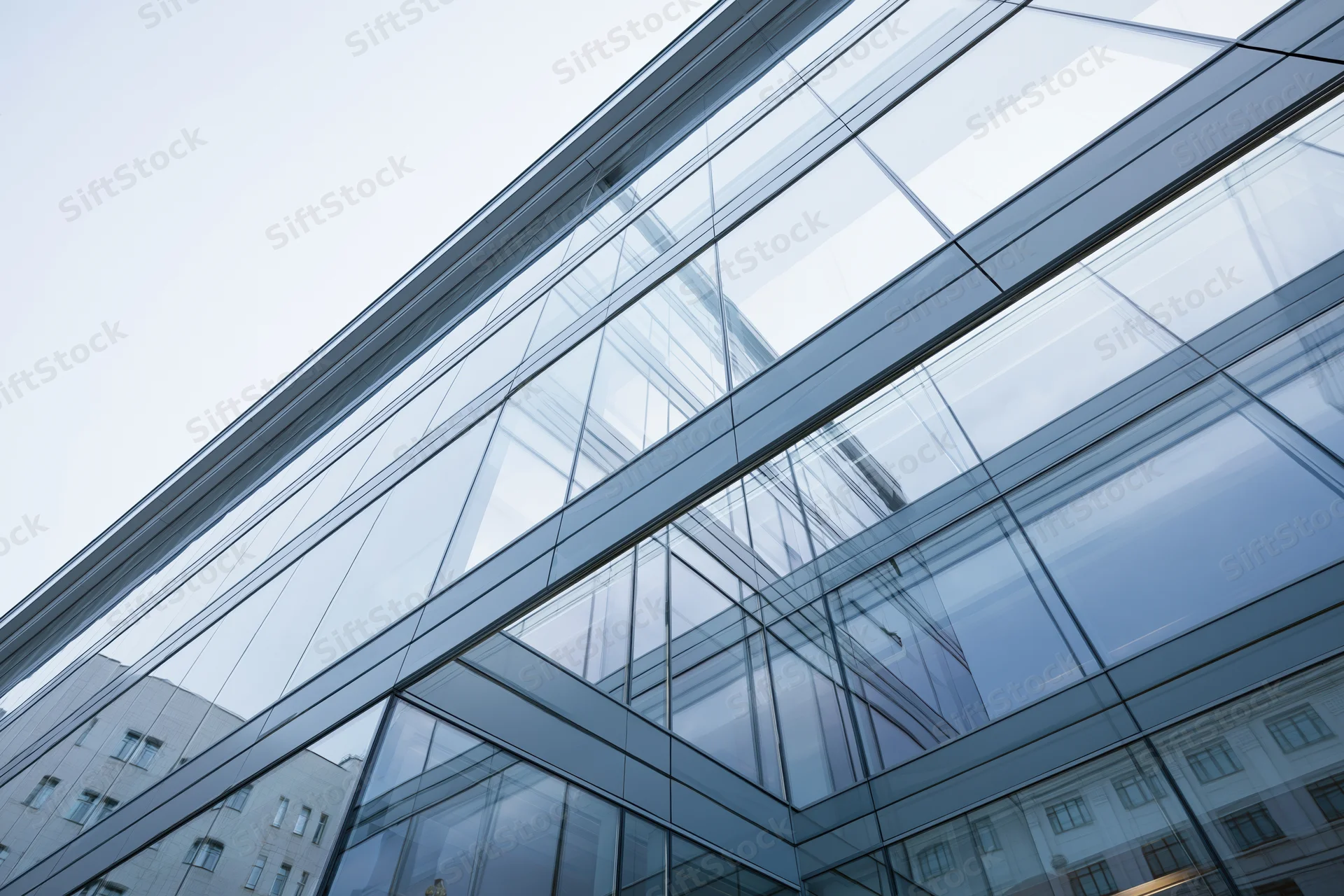 Modern glass building facade viewed from low angle looking upward