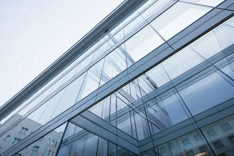 Modern glass building facade viewed from low angle looking upward