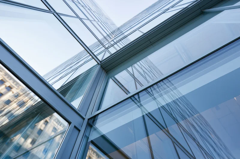 Modern glass building facade viewed from low angle looking up