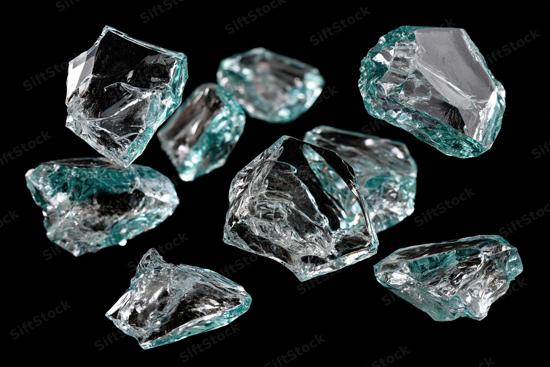 Broken glass shards scattered against a pure black background