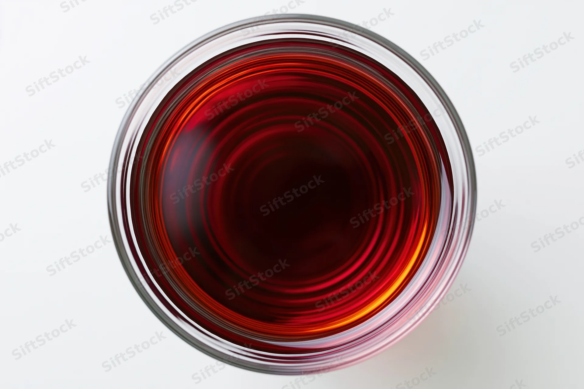 Red wine in a glass viewed from directly above on a white surface