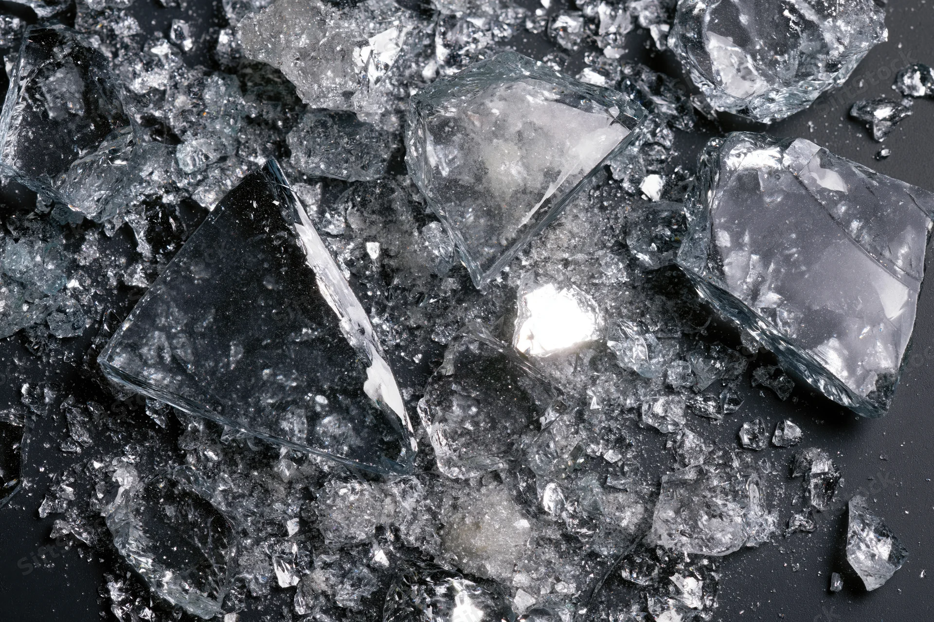 Scattered shards of broken glass lying on a dark surface