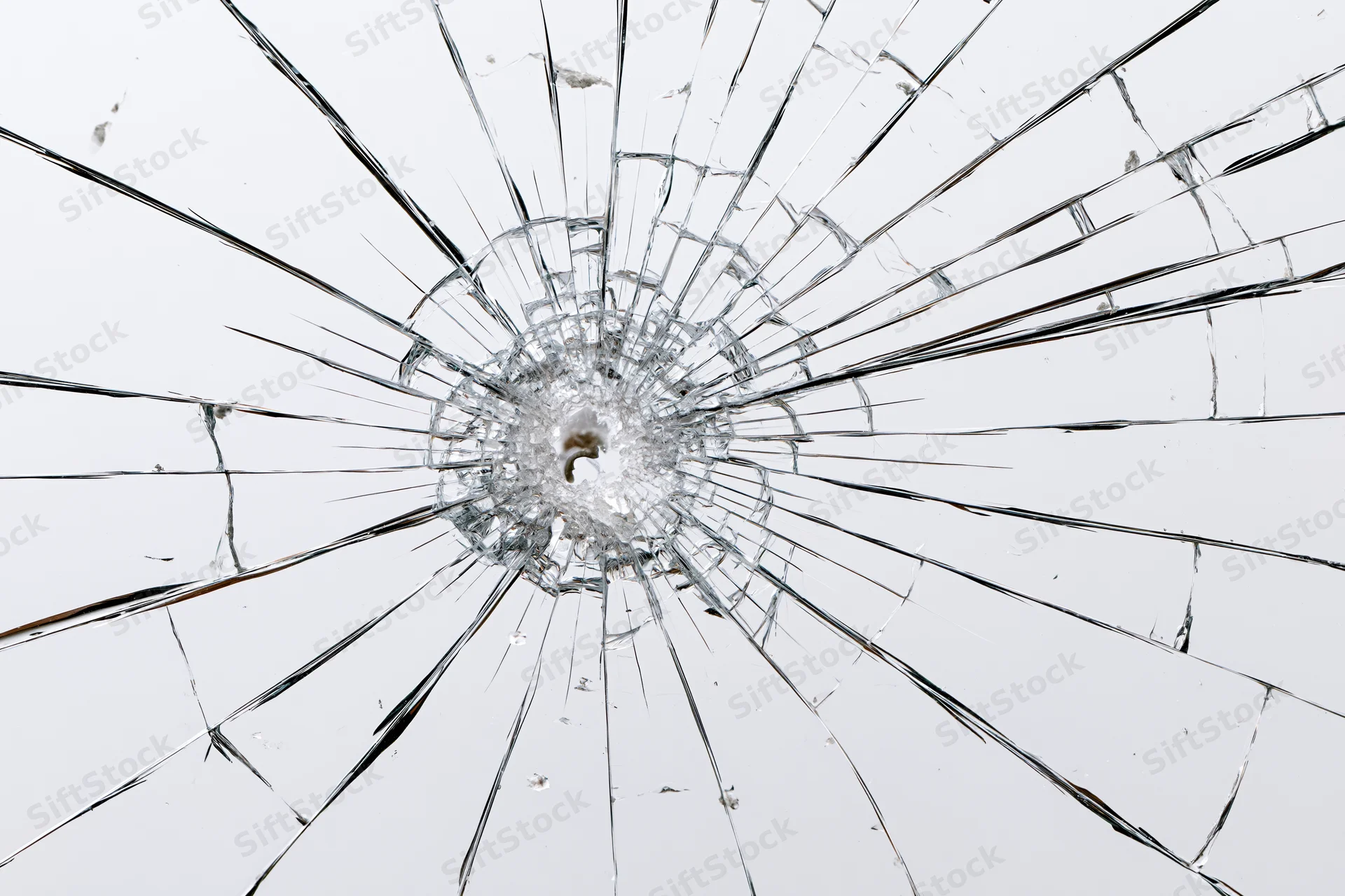 Shattered glass pane with central impact point radiating cracks across surface