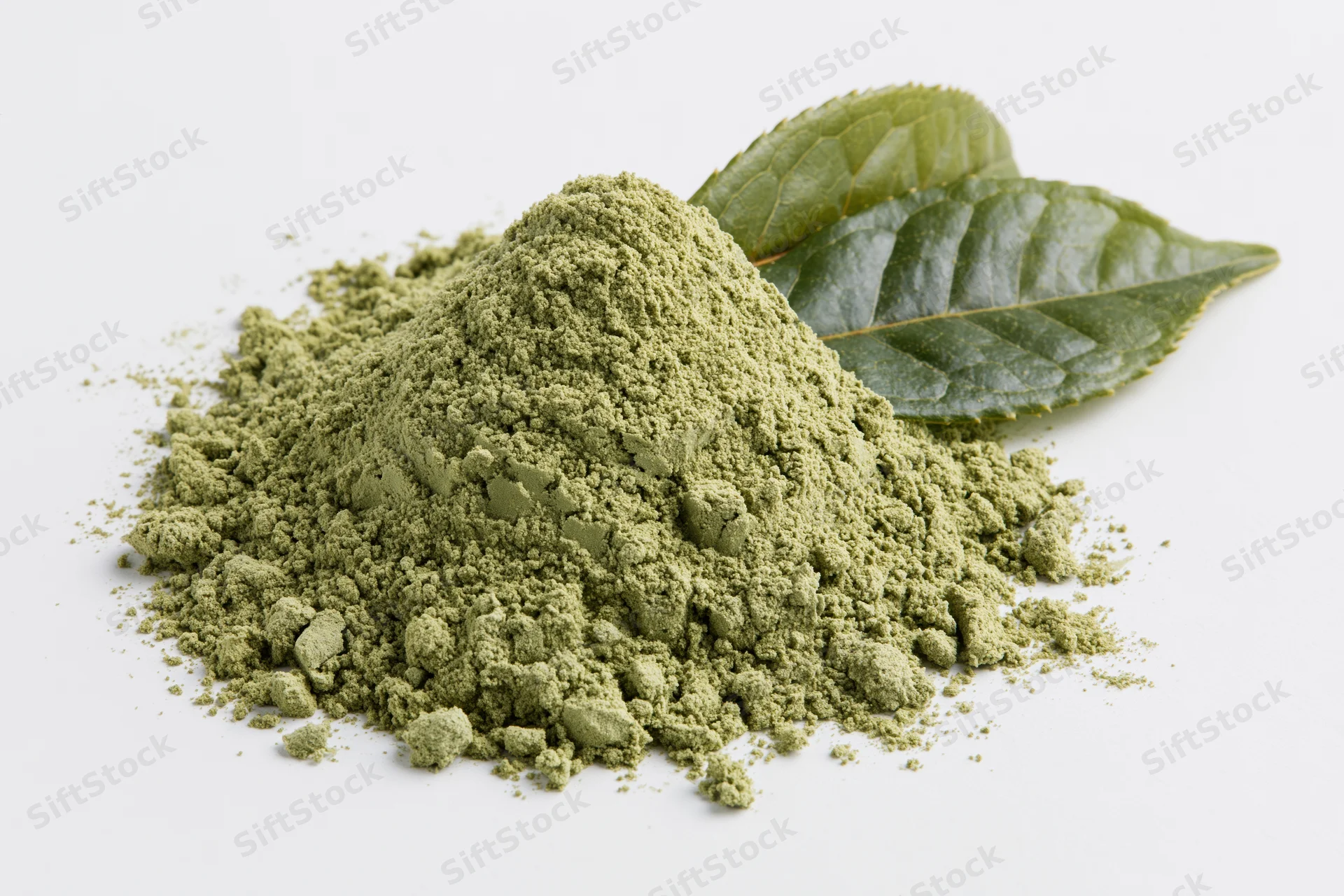 Small mound of matcha green tea powder with two fresh tea leaves on white background