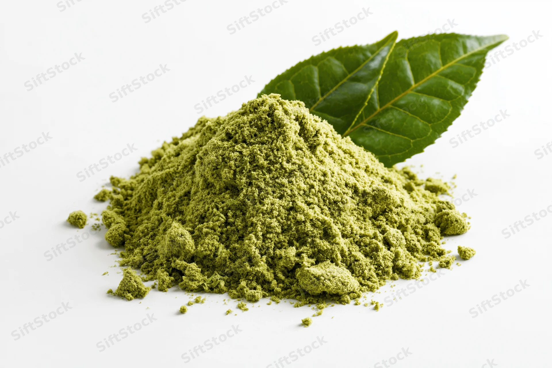 Mound of matcha green tea powder with two fresh tea leaves on white background