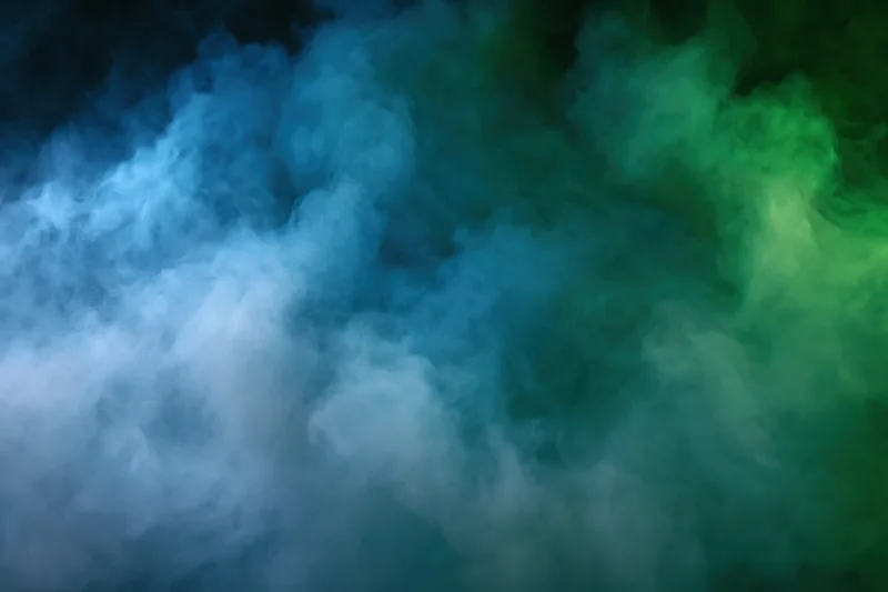 Thick billowing smoke filling the frame in abstract blue and green hues