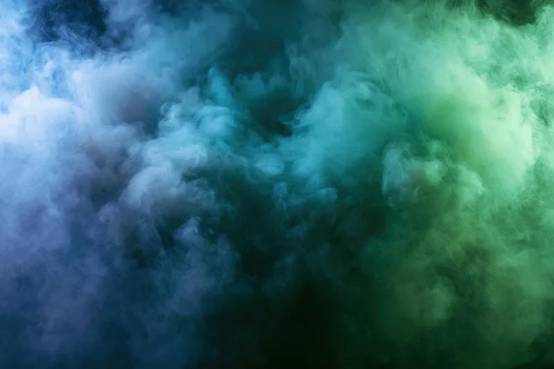 Thick billowing smoke filling the frame in abstract swirling patterns with blue and green gradients